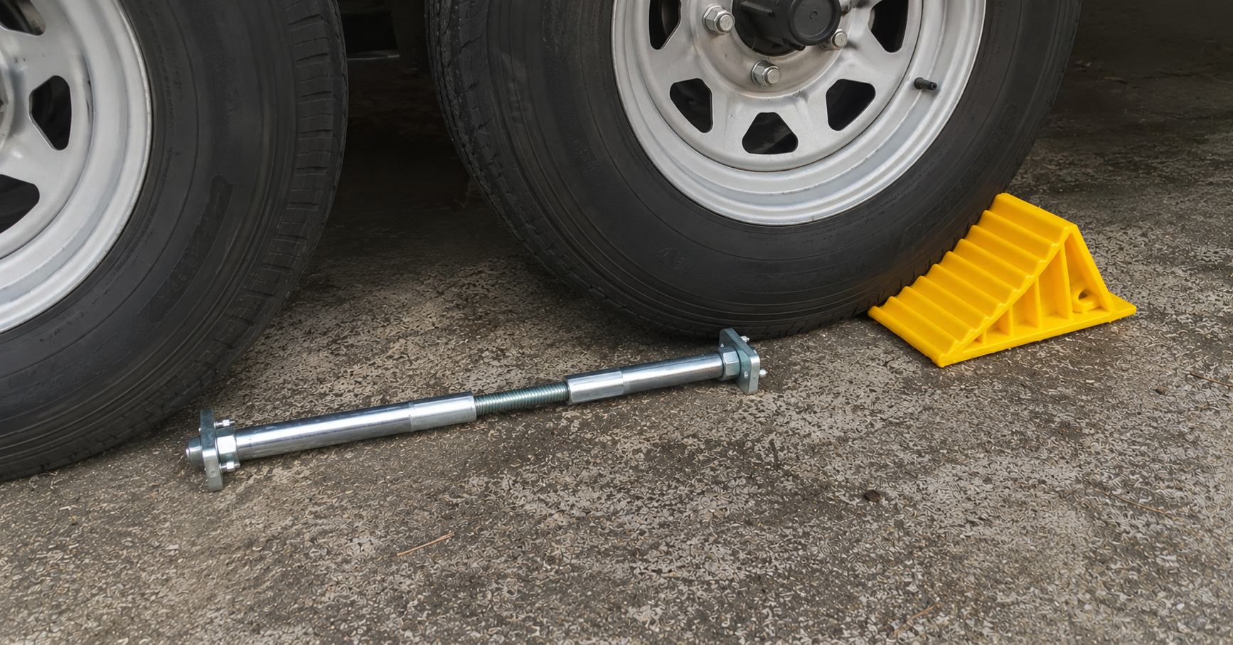 BAL X-Chock wheel stabilizer and Camco yellow wheel chock positioned beside tandem axle RV tires on concrete