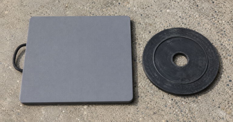 Camco heavy duty jack pad and RV SnapPad XTRA circular rubber pad on concrete campground surface