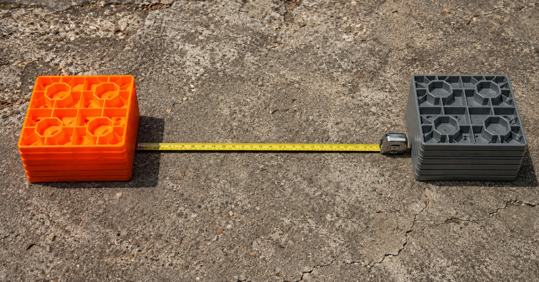 Tri-Lynx orange leveling blocks vs Andersen STAX gray leveling blocks on concrete campground surface